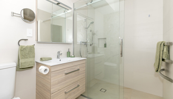 Renovated bathroom with timber-look vanity and frameless glass shower