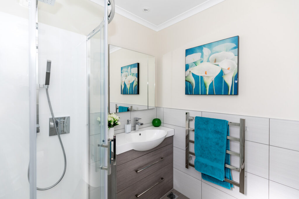 Bathroom shower and vanity with teal towel
