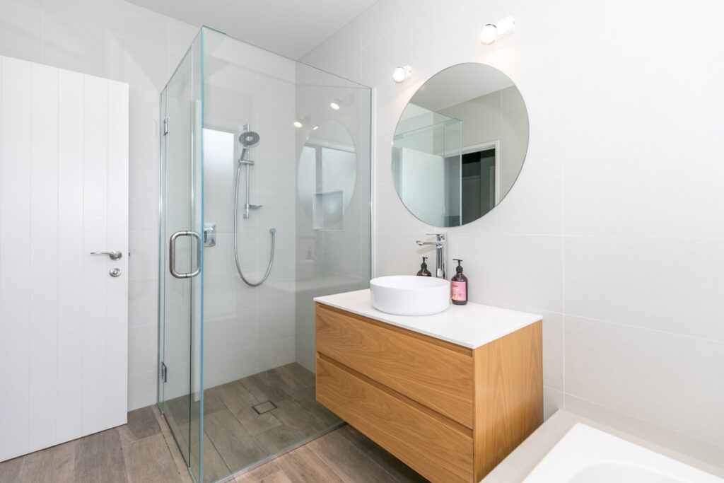 Ensuite with timber vanity, vessel basin and round mirror