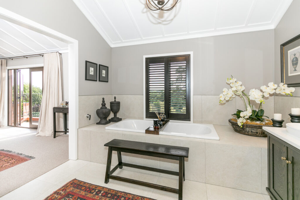 Luxury ensuite with built-in bath and window shutters