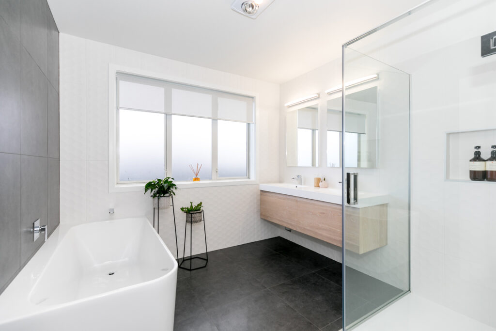 Modern bathroom with freestanding bath and dark tiles