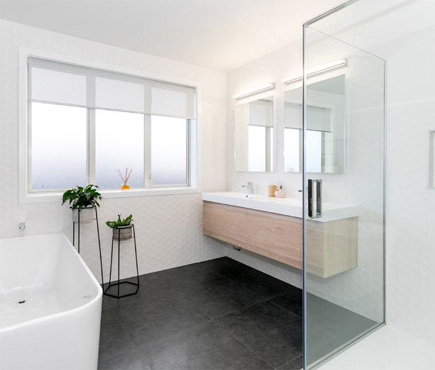 Modern bathroom with freestanding bath and dark tiles